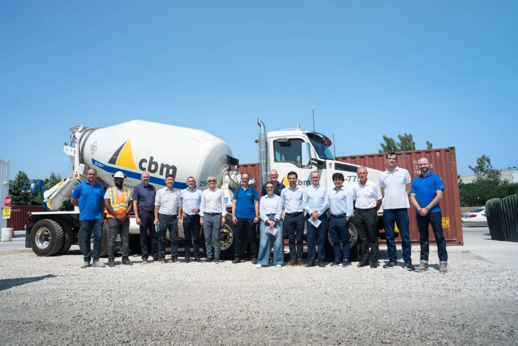 CBM employees pose together in front of a ready-mix concrete truck.