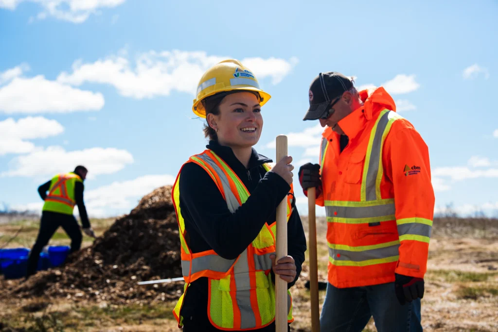 Sustainable Concrete Solutions - workers in hard hats and safety vests with shovels at an outdoor site